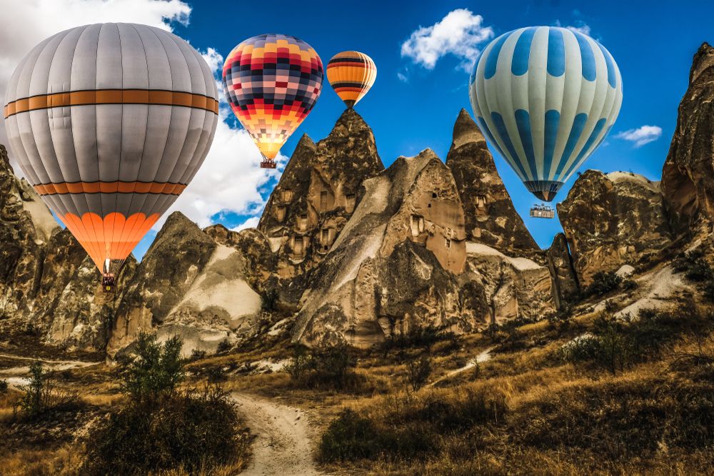 Balloons in the sky in Cappadocia with the mountains as a backdrop